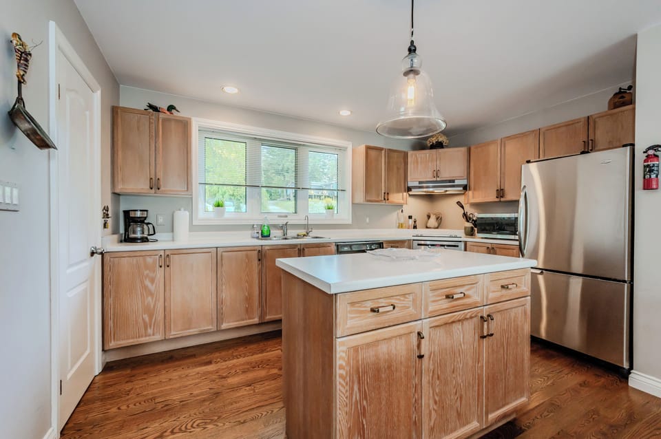 Prepare meals in the spacious and well-appointed kitchen, featuring stainless steel appliances, oak cabinets, and a center island. Enjoy the comfort of a homey yet modern kitchen, perfect for hosting after a day exploring the Bruce Peninsula or kayaking on Georgian Bay.
