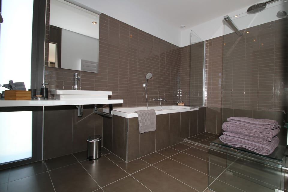Bathtub, designer toiletries, hair dryer, bathrobes