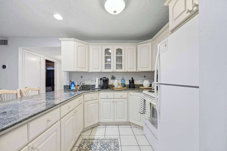 Bright kitchen with white cabinetry and granite countertops for a clean cooking space