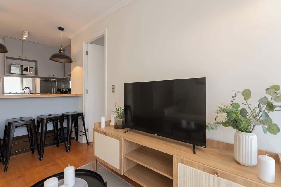 Relax in this cozy living area with a large TV and stylish decor, perfect for unwinding after exploring the city.