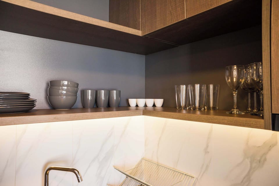 Modern kitchen with elegant dishware and stylish lighting, perfect for culinary enthusiasts.