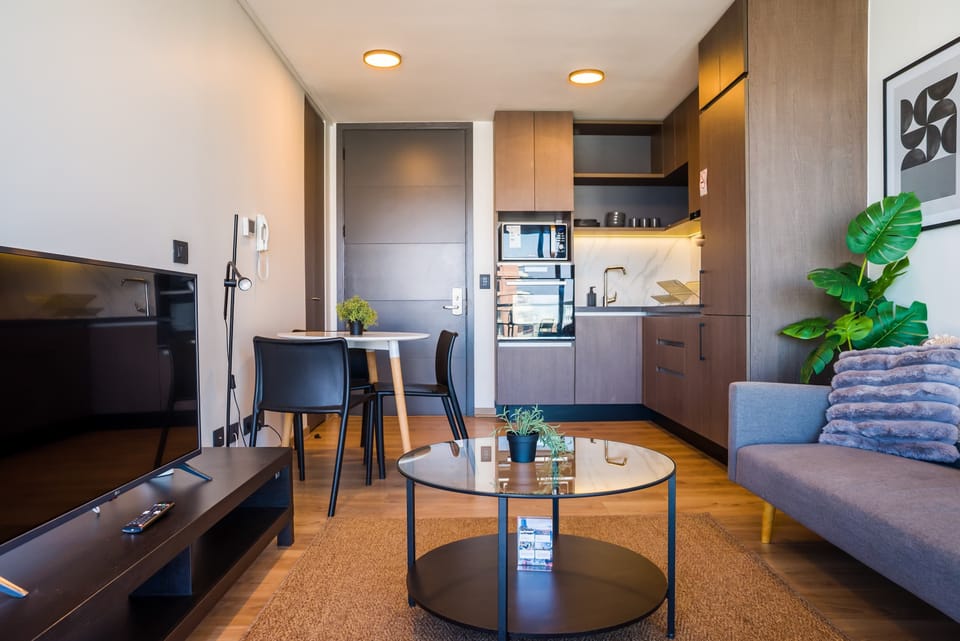 Modern living area with sleek kitchen and cozy seating, perfect for relaxation and dining.