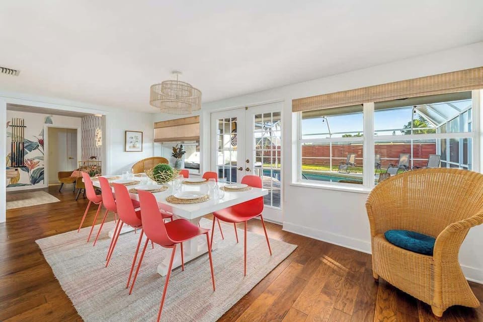Dining room table that sits 10 with french doors leading to outside patio with pool.