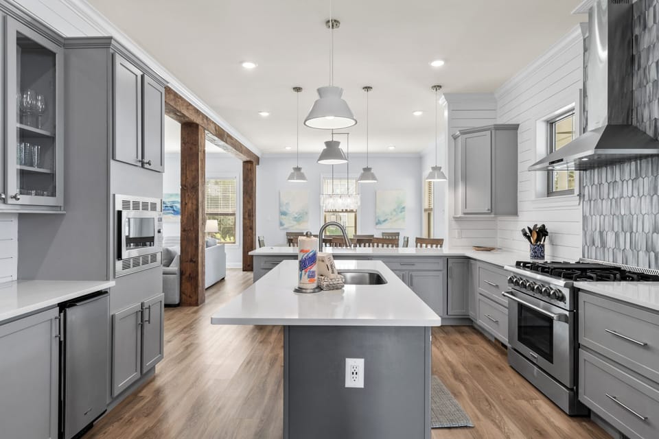 Step into your dream kitchen with elegant gray cabinetry, gleaming quartz counters, and professional-grade appliances ready for culinary adventures.