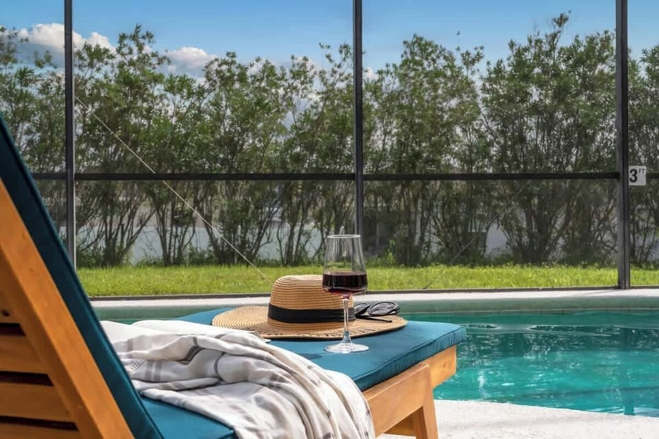 Unwind with a glass of wine and a serene view by the pool. This cozy outdoor seating area is perfect for relaxing afternoons or quiet evenings, enjoying snacks and conversation under the Florida sky.