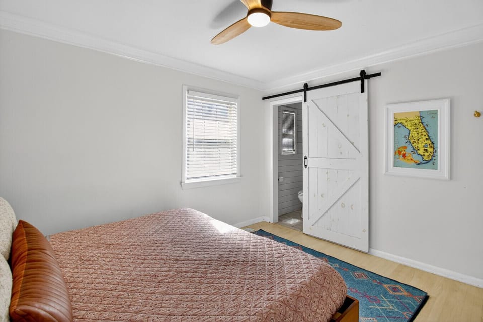 Charming bedroom with a rustic sliding barn door and soft linens — a cozy, comfortable space to unwind.