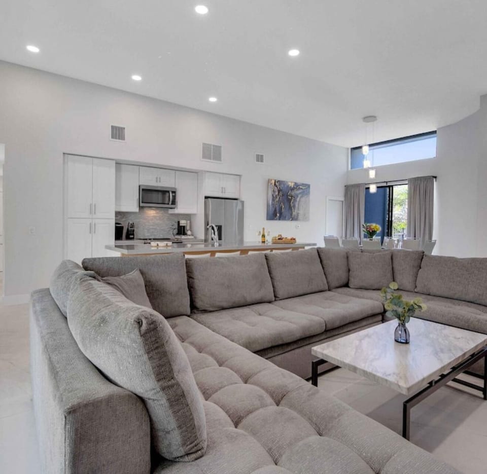 Spacious living area, high ceilings, sectional sofa, Smart TV.