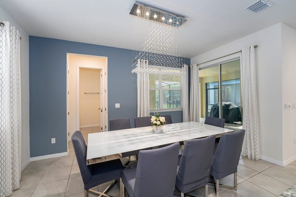 Bright dining area with a modern table, stylish chairs, and large windows.