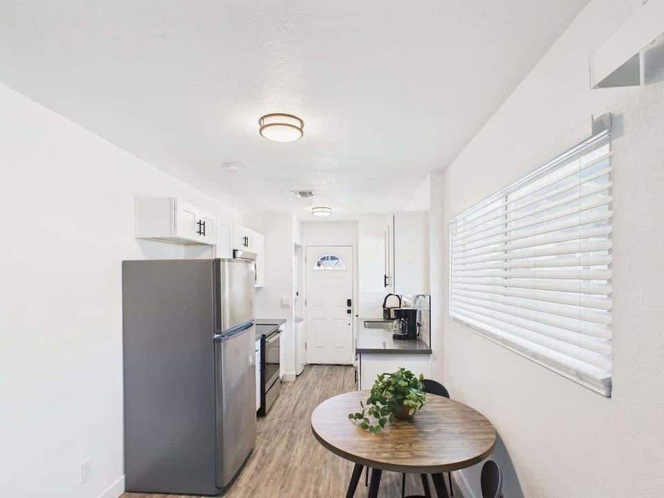 Fully equipped kitchen stocked with basic cooking essentials, stainless steel appliances, access to the shared backyard, and a washer and dryer.