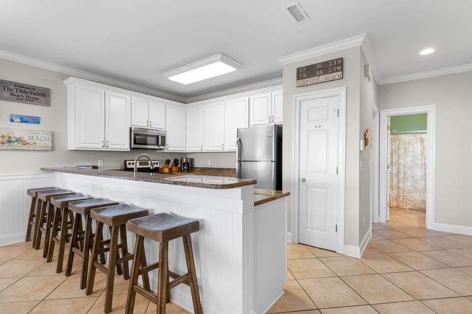 Your spacious kitchen features granite counters, stainless appliances, and a breakfast bar perfect for morning coffee or casual meals together.