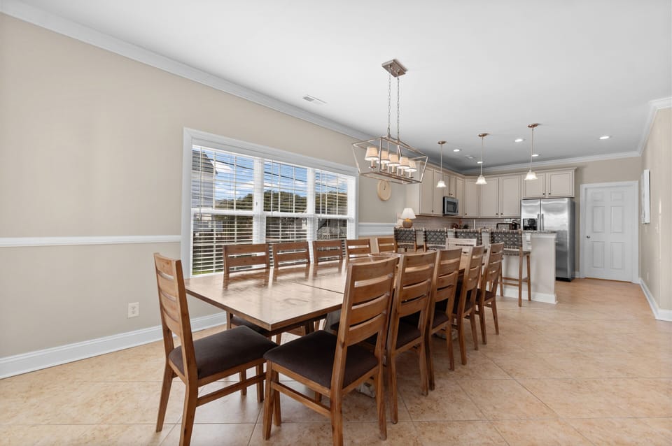 Gather around this spacious dining table where your group can share memorable meals together, with a fully-equipped kitchen ready for your culinary adventures.