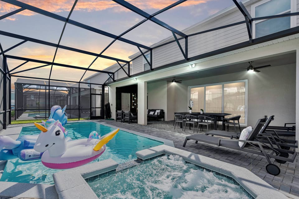Step into your private oasis, featuring a shimmering pool nestled under a protective screen, perfect for evening swims. Relax on sleek lounge chairs while enjoying the vibrant sunset views, making it an ideal spot for gatherings.