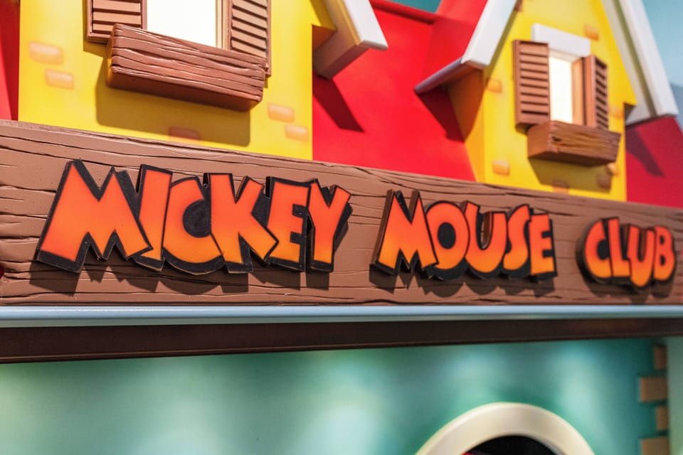 Experience a whimsical world filled with vibrant colors and charming decor that captures the spirit of fun. The playful "Mickey Mouse Club" sign invites you to embrace your inner child in this delightful atmosphere.