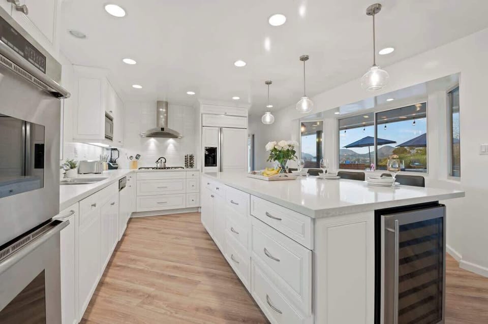 This kitchen is a blend of modern design and practicality, with a sleek island counter, built-in appliances, and comfy chairs for casual dining. The spacious layout provides ample room for meal prep and entertaining.