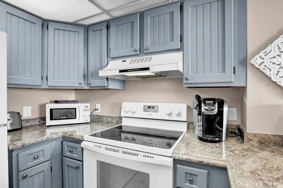 A fully equipped kitchen with modern appliances and charming blue cabinets. Whether you want to whip up a quick breakfast or a full dinner, you have everything you need.