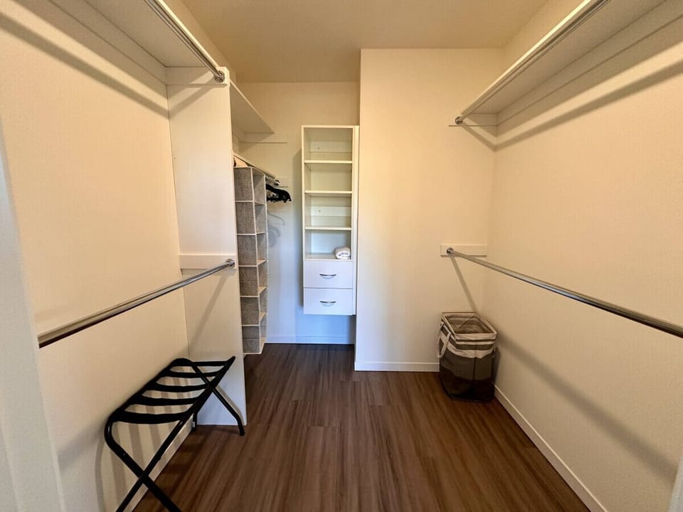A serene bedroom featuring a plush queen-sized bed and an expansive walk-in closet for all your storage needs