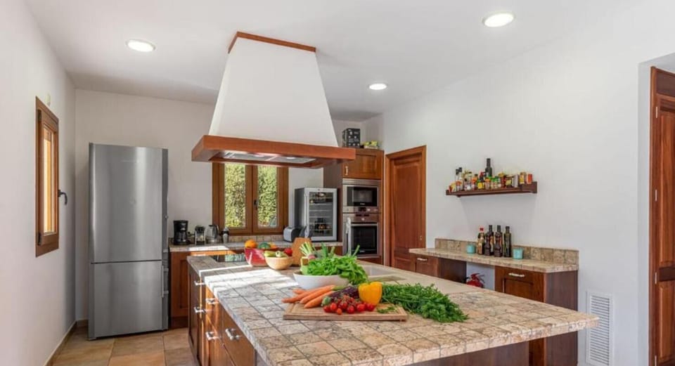 Fully equipped kitchen at Finca Es Foners with central island, modern appliances and spacious layout in Felanitx.