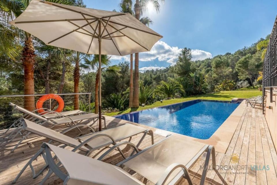 Private pool at Finca Es Foners with wooden terrace, sun loungers and nature views in Felanitx, Mallorca