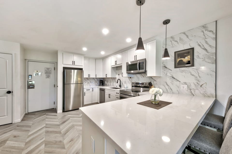 Your sleek kitchen features marble backsplash, stainless appliances, and a spacious island perfect for cooking memorable meals.