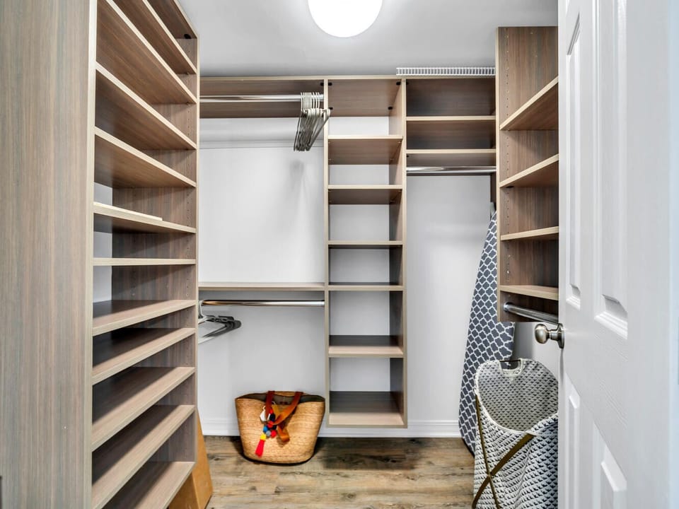 Your spacious walk-in closet features custom wood shelving and ample hanging space to organize all your belongings perfectly.