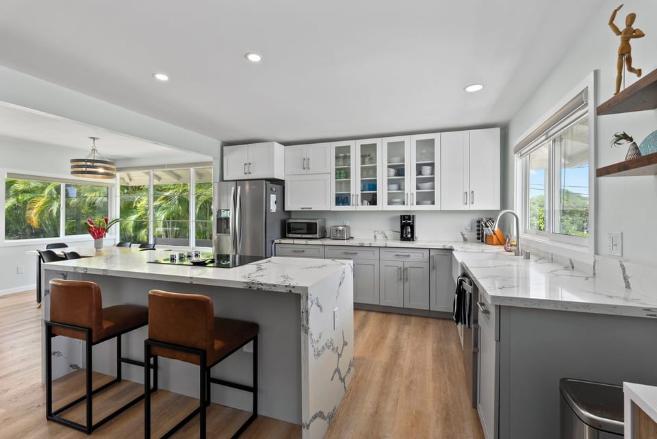Modern and spacious, this fully equipped kitchen features sleek countertops and a breakfast bar.
