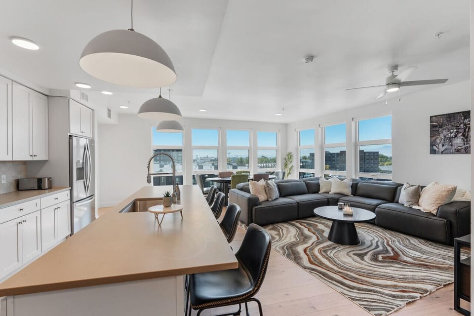 Beautifully designed living room. 75` TV, leather sofa and amazing views of mountains and city skyline.