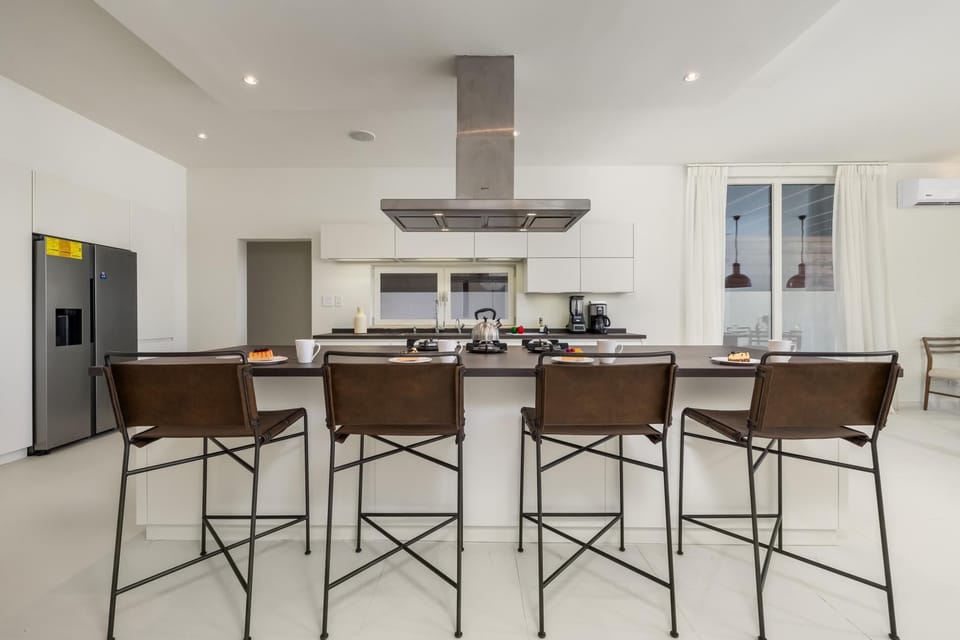This modern kitchen features a large island with seating for four, perfect for casual dining or gathering with friends and family.