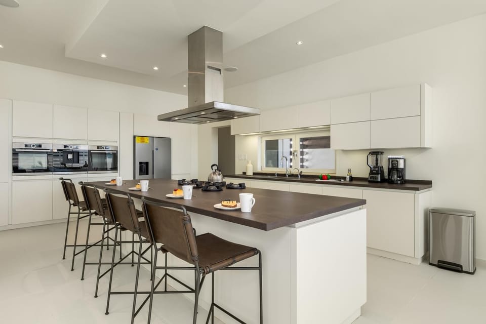 The sleek countertop provides ample space for meal prep and serves as a convenient spot for morning coffee or evening drinks, all within the heart of the kitchen.