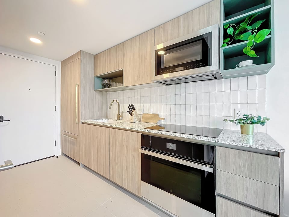 Kitchen with terrazzo counters, gold fixtures, and sleek built-in appliances.