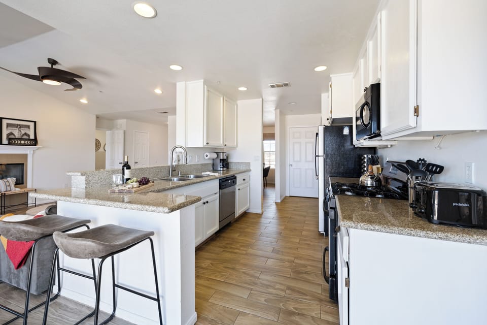 Bright, fully equipped kitchen with bar seating and ample counter space.