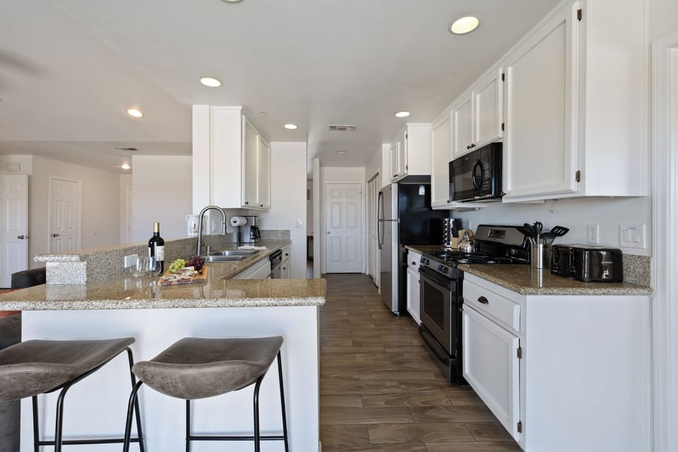 Bright, fully equipped kitchen with bar seating and ample counter space.