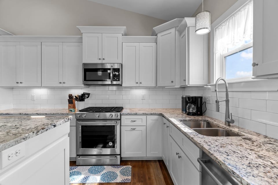 Modern White Kitchen w/ Breakfast Bar Seating, Stainless Steel Appliances, Refrigerator, Oven, Stovetop, Microwave, Refrigerator, and Much More