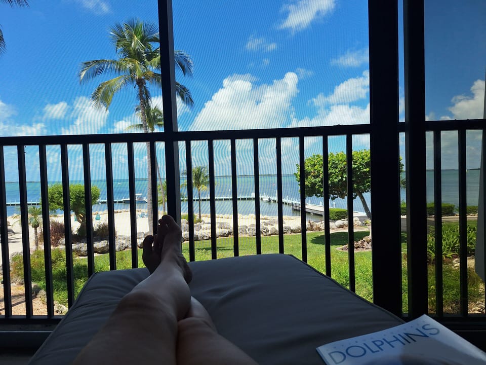 Balcony chaise overlooking open water views and sandy beach