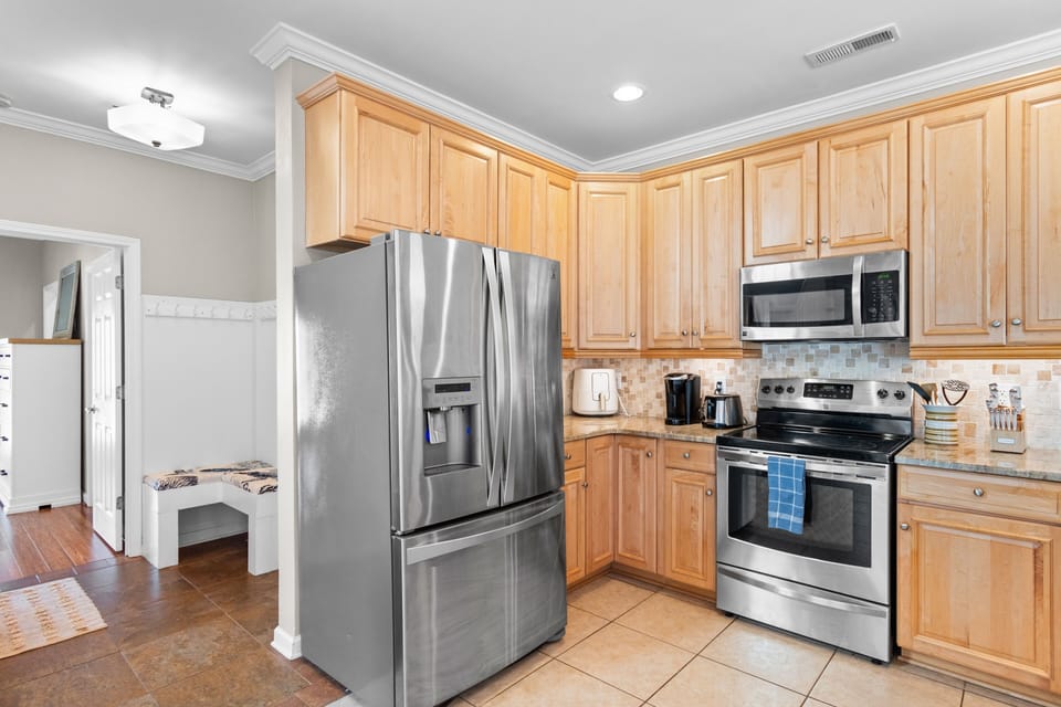 Your fully equipped kitchen features warm wood cabinets, stainless steel appliances, and granite countertops—perfect for preparing memorable meals during your stay.