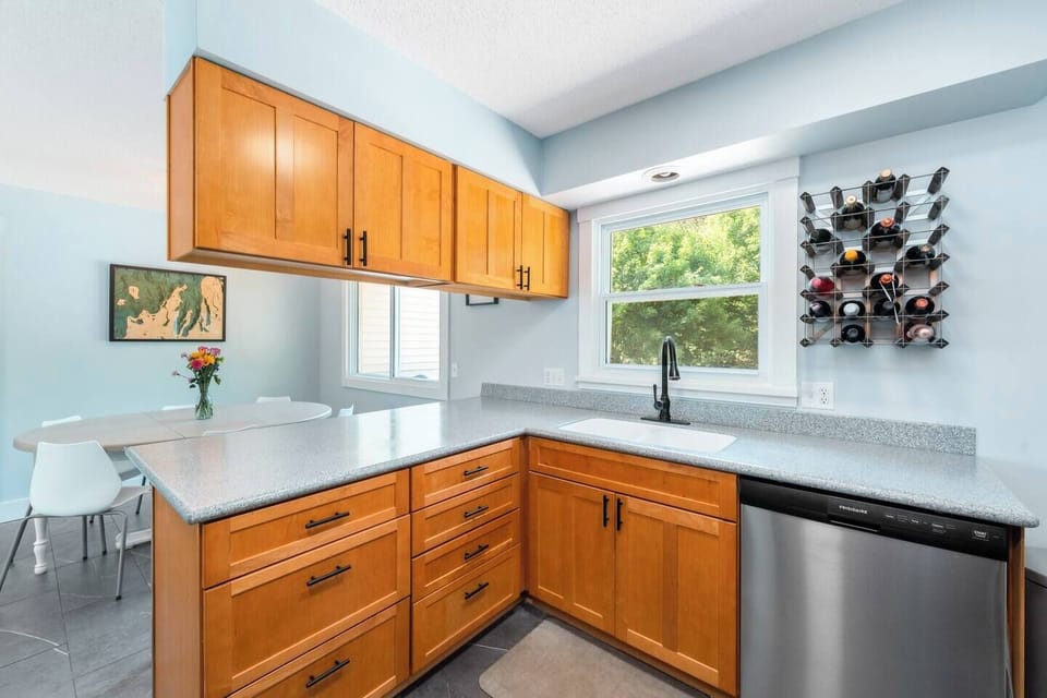 The kitchen features solid surface countertops, plenty of storage (especially for wine), and a view of the large backyard from the sink.