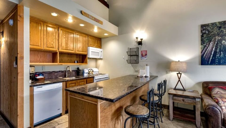 repare meals in the modern kitchen equipped with stainless steel appliances and a convenient breakfast bar.