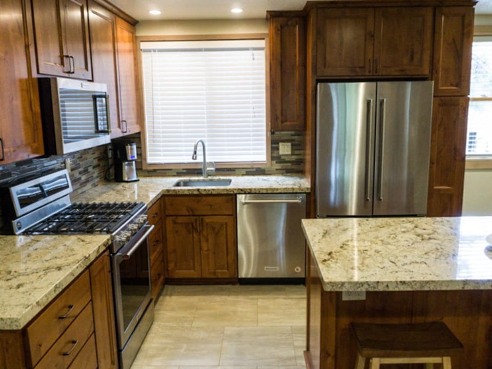 Fully equipped kitchen featuring granite countertops, stainless steel appliances, and custom cabinetry, perfect for gourmet cooking.