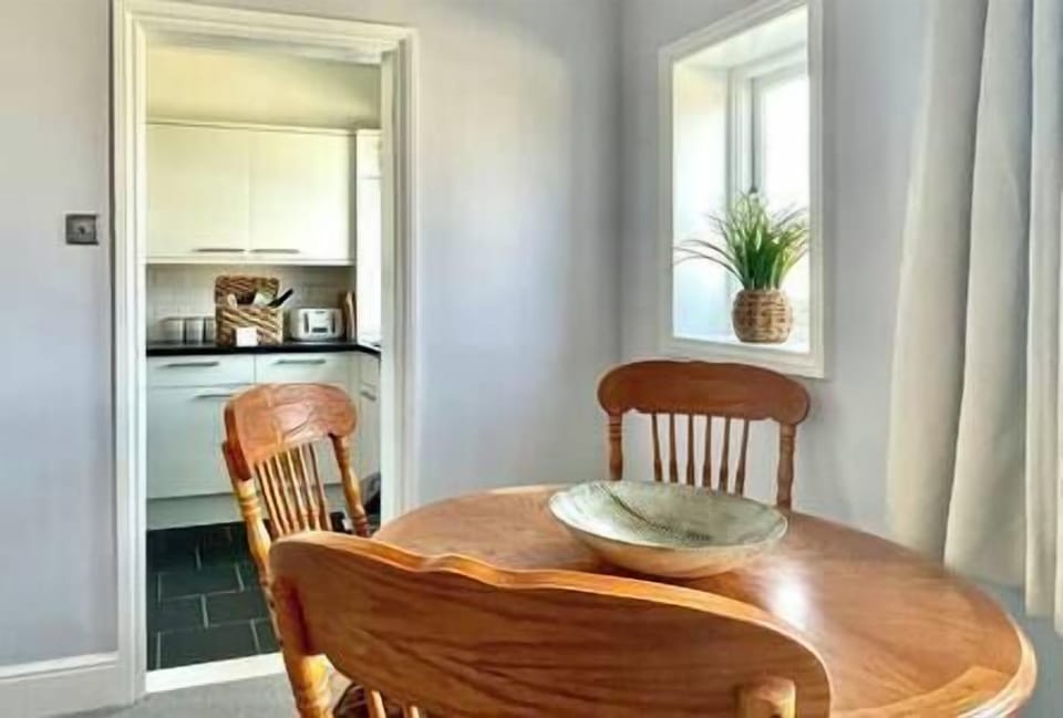 Large dining table with four padded chairs