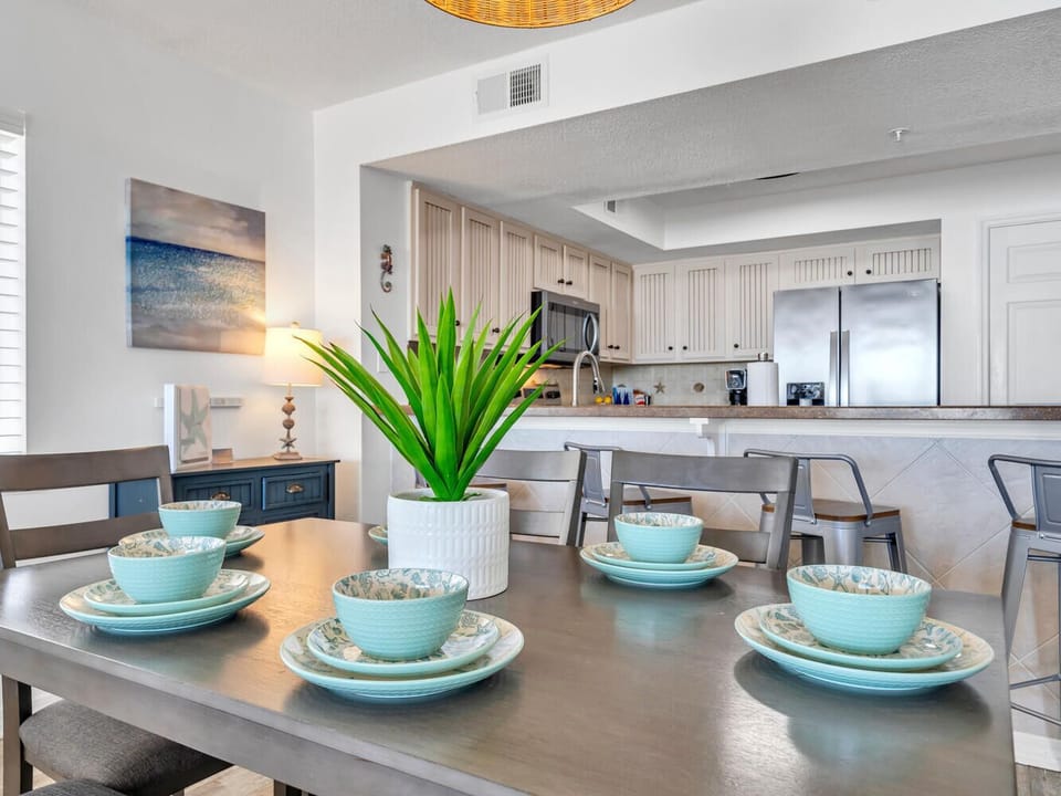Gather around this elegant dining table with coastal-inspired turquoise dinnerware, perfect for sharing memorable meals with your travel companions.