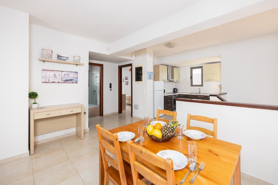 Upstairs unit: open-plan living room with sofa, dining area, kitchen, A/C, WiFi internet, and satellite TV