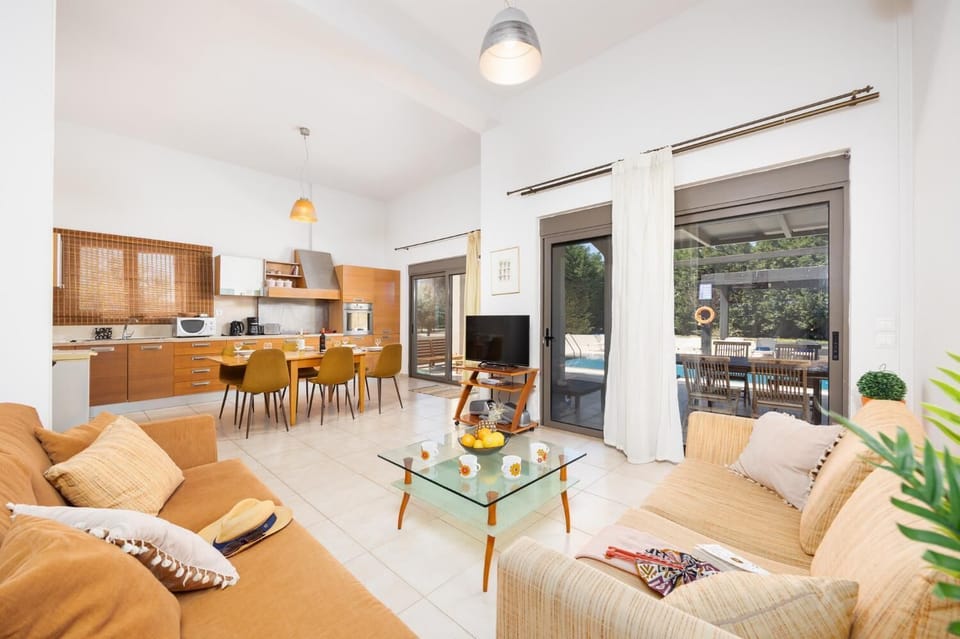 Main unit: open-plan living room with sofas, dining area, kitchen, A/C, WiFi internet, and satellite TV