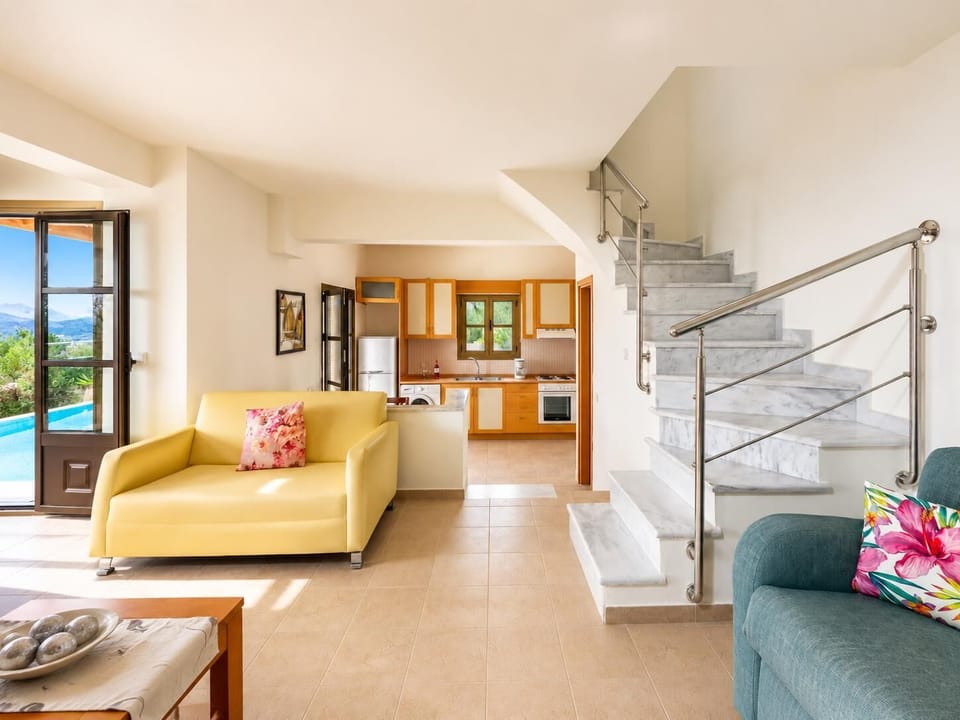Open-plan living room with sofa, dining area, kitchen, A/C, WiFi internet, and satellite TV