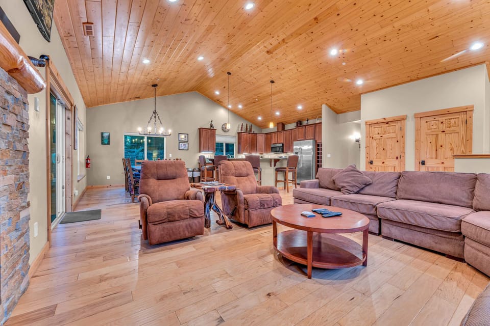 Living Room: Large l-shaped couch, 2 recliners, 55” Smart TV, gas fireplace, soaring windows, open layout, upper floor