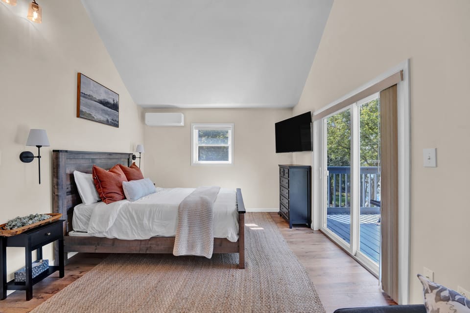 Rest and recharge in the spacious main bedroom with serene lake views.
