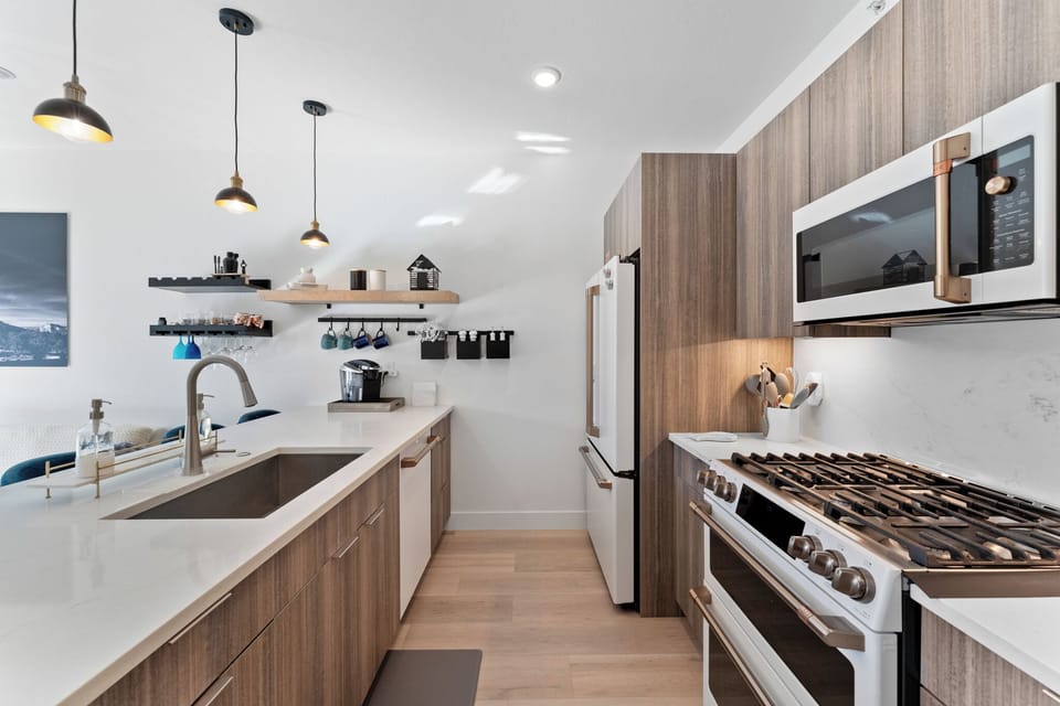 Cook your favorite meals in this sleek modern kitchen with premium appliances, marble counters, and thoughtful storage.