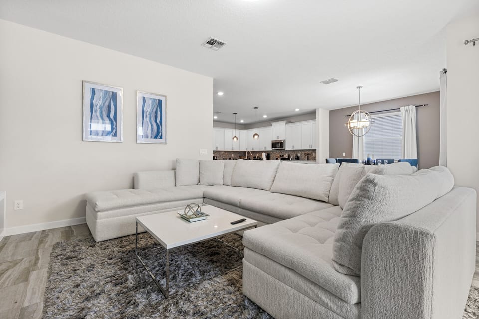 - Indulge in comfort of this spacious living area connected to an open kitchen - Comfortable seating and modern furnishings create a perfect gathering space - Ideal for socializing, with easy access to the kitchen and dining space
