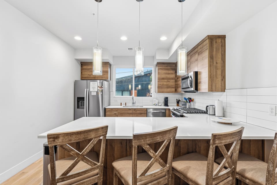 Gather in this bright kitchen with friends and family—your meals together will be unforgettable with modern appliances and welcoming breakfast bar seating.