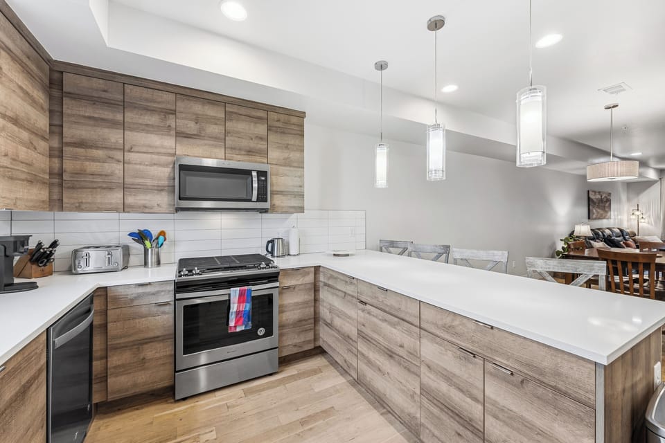 Enjoy cooking and gathering in your open-concept kitchen, where sleek countertops, modern appliances, and warm wood-toned cabinetry create the perfect backdrop for memorable meals together.