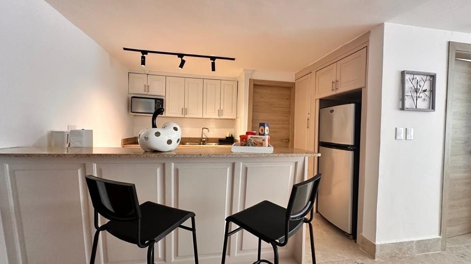 The modern kitchen area has a microwave, stove, oven, and electric coffee maker