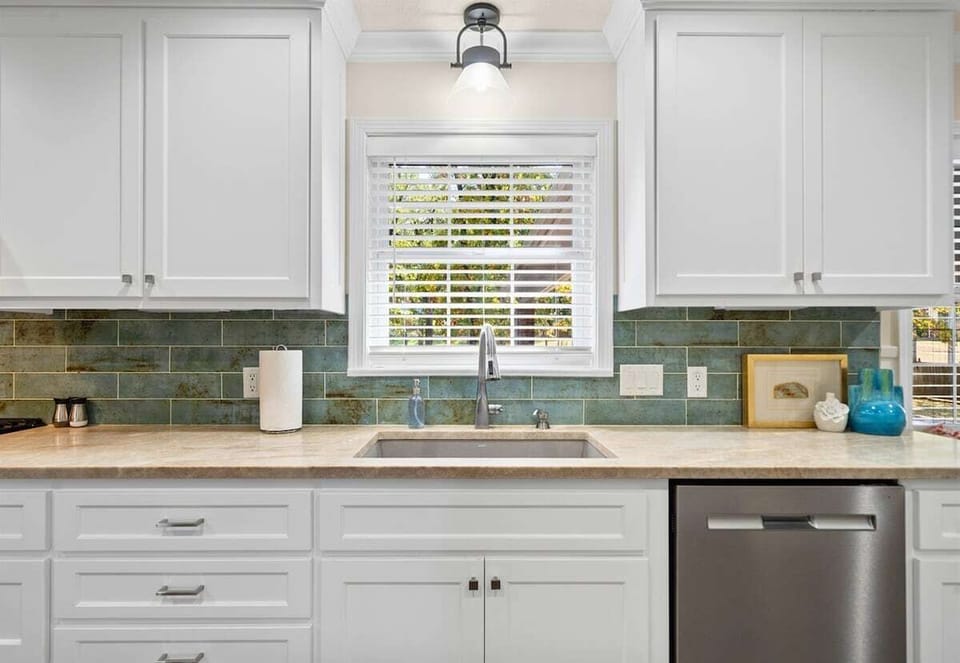 A closer look at the stylish and functional kitchen sink, with a gorgeous tile backsplash adding a modern touch.